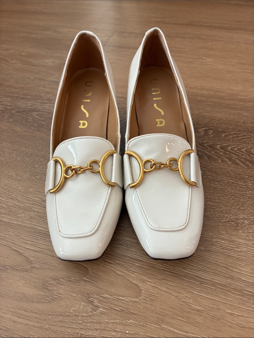 White patent heeled loafers with gold chain detail